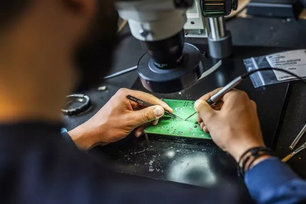 Photo of hands working with semiconductor chip.